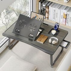 a laptop computer sitting on top of a desk next to a book shelf filled with books