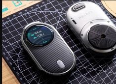 two electronic devices sitting on top of a cutting board