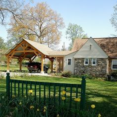 a car is parked in front of a house with a covered porch and picnic area