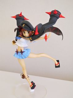 a figurine is posed on a white surface with red stars and black hair