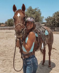 a woman standing next to a brown horse