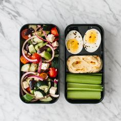 two black trays filled with vegetables and eggs