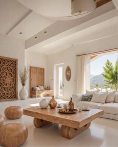 a living room filled with furniture and a large window next to a white couch covered in pillows