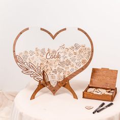 a wooden heart with words written all over it sitting on top of a white table