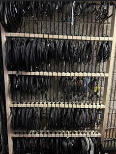 many wires and cables are stacked up on shelves