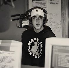 a young man wearing headphones sitting in front of a computer