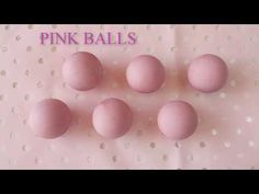 pink balls are arranged on a white surface