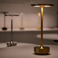 a table lamp sitting on top of a white counter next to two lamps in the background