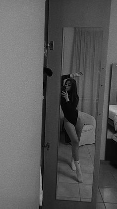 a woman taking a selfie in a mirror with her legs crossed and one leg bent