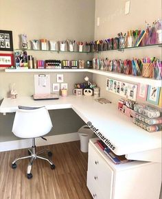 a white desk topped with lots of different colored pens and paper on top of it