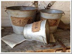 three buckets sitting on top of a wooden table next to each other with numbers painted on them