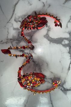 a marble table topped with red and gold jewelry