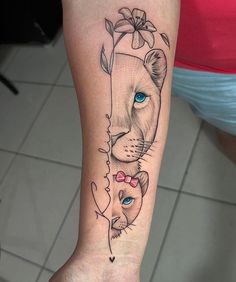 a woman's arm with a tattoo on it that has a lion and cat