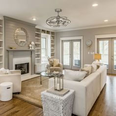 a living room filled with furniture and a fire place in the middle of a room