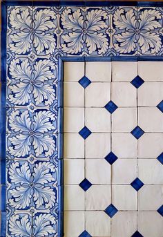 a blue and white tile wall with an ornate design