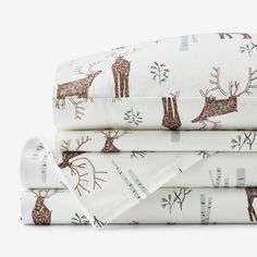 three sheets with deer and trees on them are folded up in front of each other