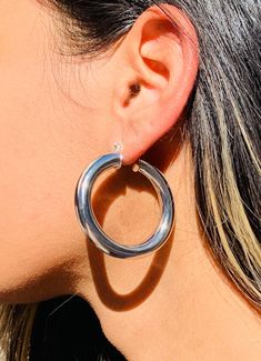 Crafted with meticulous attention to detail, these hoops showcase a generous size and a chunky design that commands attention. Embrace the bold and striking allure of the large chunky silver-plated hoops, adding a touch of modern elegance and self-assured style to your accessory collection. Hoop Size: 7.5mm x 45mm Width: 7mm Clasp: Push Back  Material: Stainless Steel with Rhodium-Hypoallergenic. Tarnish Resistant. We recommend keeping abrasive chemicals away from the jewelry for the items to la Chunky Hoop Jewelry, Chunky Small Hoop Jewelry, Hoop Earrings Big, Hoop Earrings Chunky, Large Silver Hoop Earrings, Thick Hoop Earrings, Hoops Silver, Chunky Hoop Earrings, Earrings Big