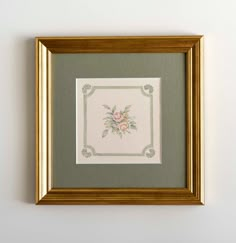 a framed painting with flowers on the wall