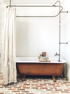 a bathroom with a tub, shower curtain and books on the shelf next to it