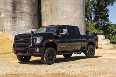 a black truck parked in front of a silo