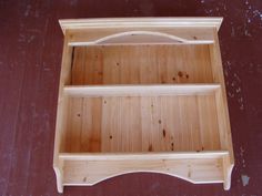 a wooden shelf sitting on top of a red floor