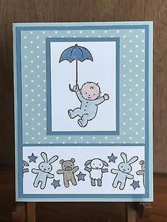 a card with a baby holding an umbrella