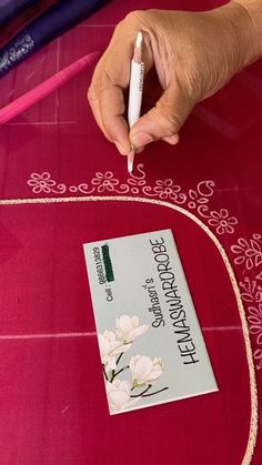 a person is making a flower design on a piece of fabric with a crochet hook