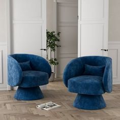 two blue chairs sitting next to each other on top of a hard wood floored floor