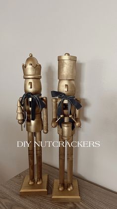 two gold nutcrackers with black bows on them