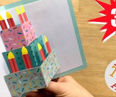 a hand holding up a 3d birthday card with candles in it and the words red ted on