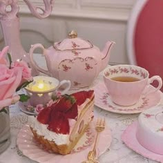 there is a piece of cake on the table with pink flowers and teacups