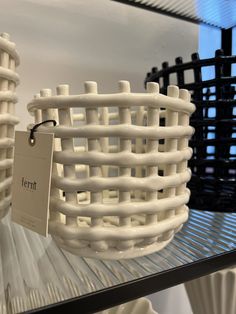 two white baskets sitting on top of a glass shelf