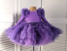 This beautiful dress is sure to please your baby. The dress has a very beautiful unusual fluffy skirt. The dress of a rich lavender color is sewn from a fabric with a shiny coating. The dress shimmers very beautifully and looks luxurious. On the back of the dress there is a long zipper and a beautiful bow. the dress is knee-length. The sleeve in the dress has a length of 3/4, but at your request it can be made long or removed completely. The dress is sewn to order within 7-10 days. If you have any questions, please write to me and I will do my best to make you satisfied with your purchase in my store. Booties can be sewn into the dress set(paid additionally) Booties size (outer sole length): 9.5 cm 0-3 months 10.5 cm 3-6 months 11.5 cm 6-9 months 12.5 cm 9-12 months Lavender Fitted Princess Dress For Dress-up, Lavender Princess Dress For Party, Lavender Ruffled Dress For Birthday, Cute Fitted Purple Princess Dress, Lavender Ruffle Dress For Birthday, Elegant Lavender Princess Dress For Party, Purple Fitted Tutu Dress For Party, Fitted Purple Tutu Dress For Party, Elegant Purple Tutu Dress For Party