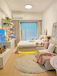 a room with a bed, couch and television in it