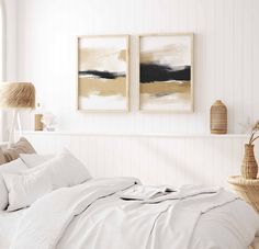 a bedroom with two paintings on the wall above the bed, and a wicker basket next to it