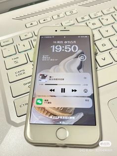 an iphone sitting on top of a white keyboard