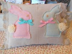 a pink and blue bunny pillow sitting on top of a bed