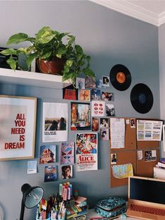 there is a desk with many pictures on the wall and a record player next to it