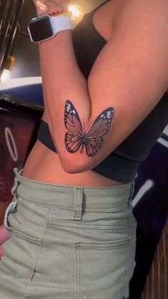 a woman's stomach with a butterfly tattoo on her left arm and the bottom half of her body