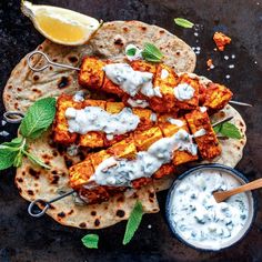 grilled chicken skewers with yogurt sauce and mint garnish