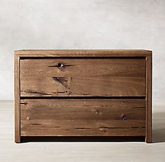 a wooden dresser sitting on top of a hard wood floor next to a white wall