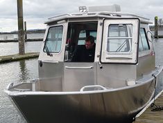 a man sitting in the driver's seat of a silver boat