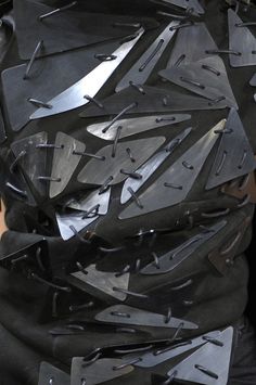 a man is covered in black metal pieces