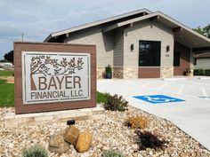 a sign for the bayer financial, inc in front of a building with landscaping