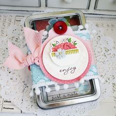 a close up of a cell phone on a lace doily with buttons and flowers