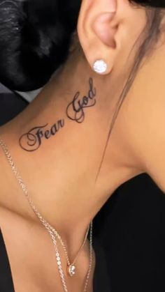 the back of a woman's neck with an inscription that reads fear god on it