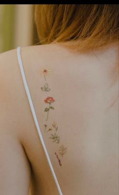 the back of a woman's shoulder with flowers painted on her arm and chest