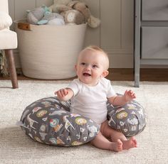 a baby is sitting on the floor and smiling