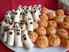 a plate with bananas, oranges and other foods on it that are decorated to look like jack - o'- lanterns