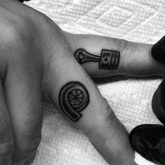 two people with tattoos on their fingers and one has a wrench in the middle